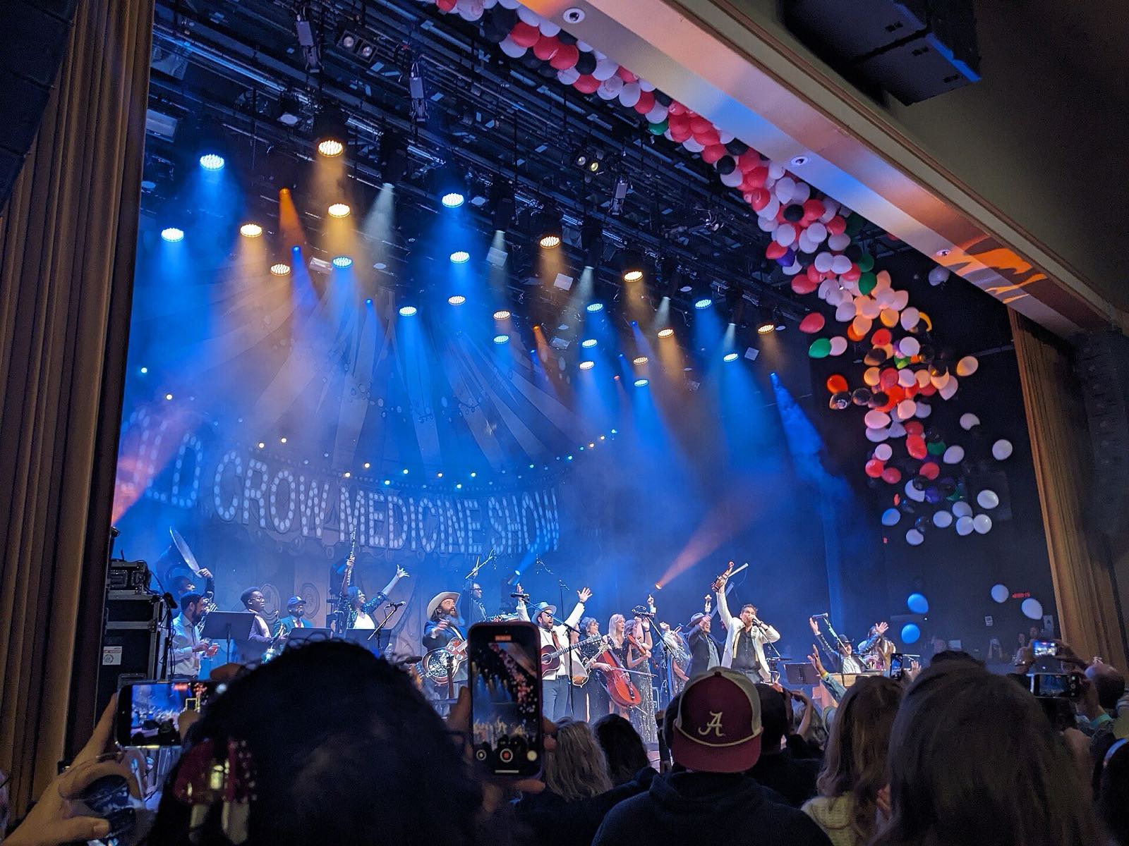 A packed crowd watching Old Crow Medicine Show on stage at the Ryman Auditorium.